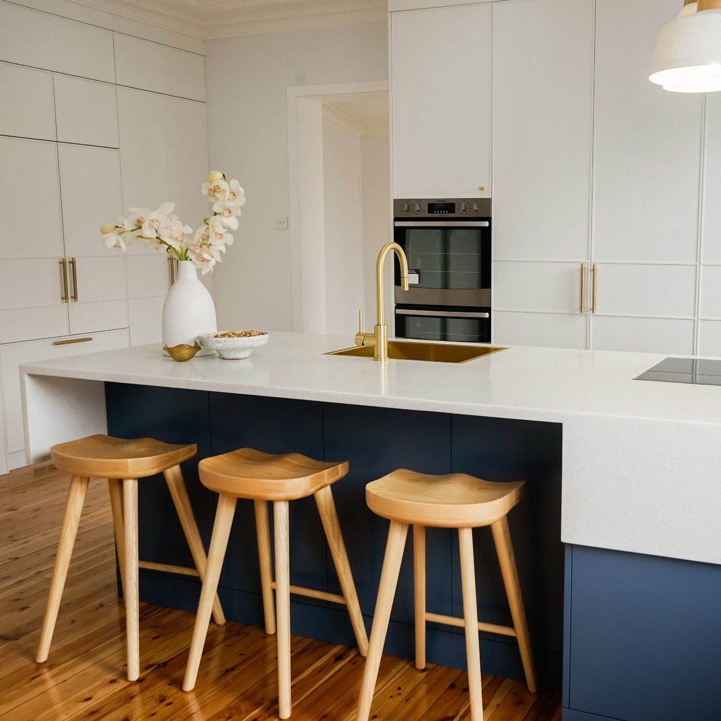 A Kitchen With a Blue Island and a Staircase — Paiano Custom Kitchens In Corrimal, NSW