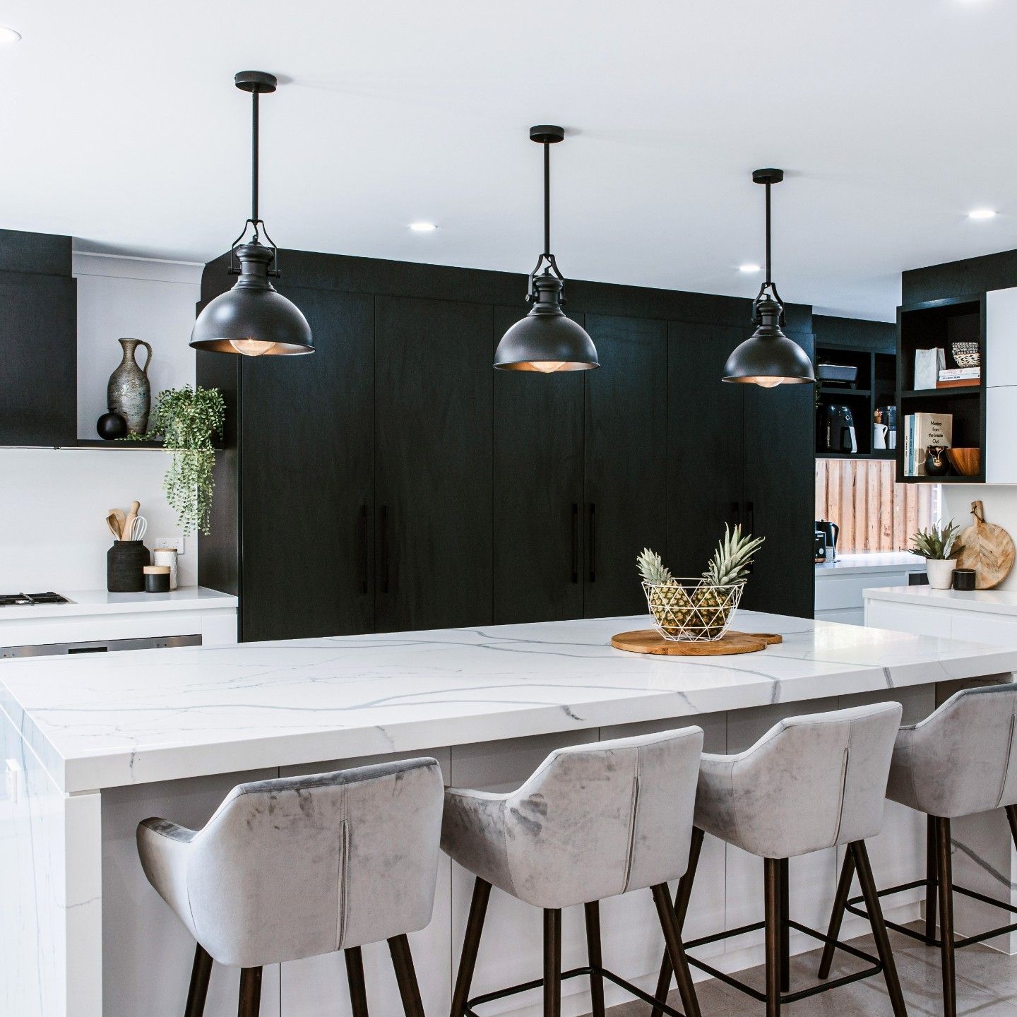 A Kitchen With Blue Cabinets and a Vase of Flowers on the Counter — Paiano Custom Kitchens In Corrimal, NSW