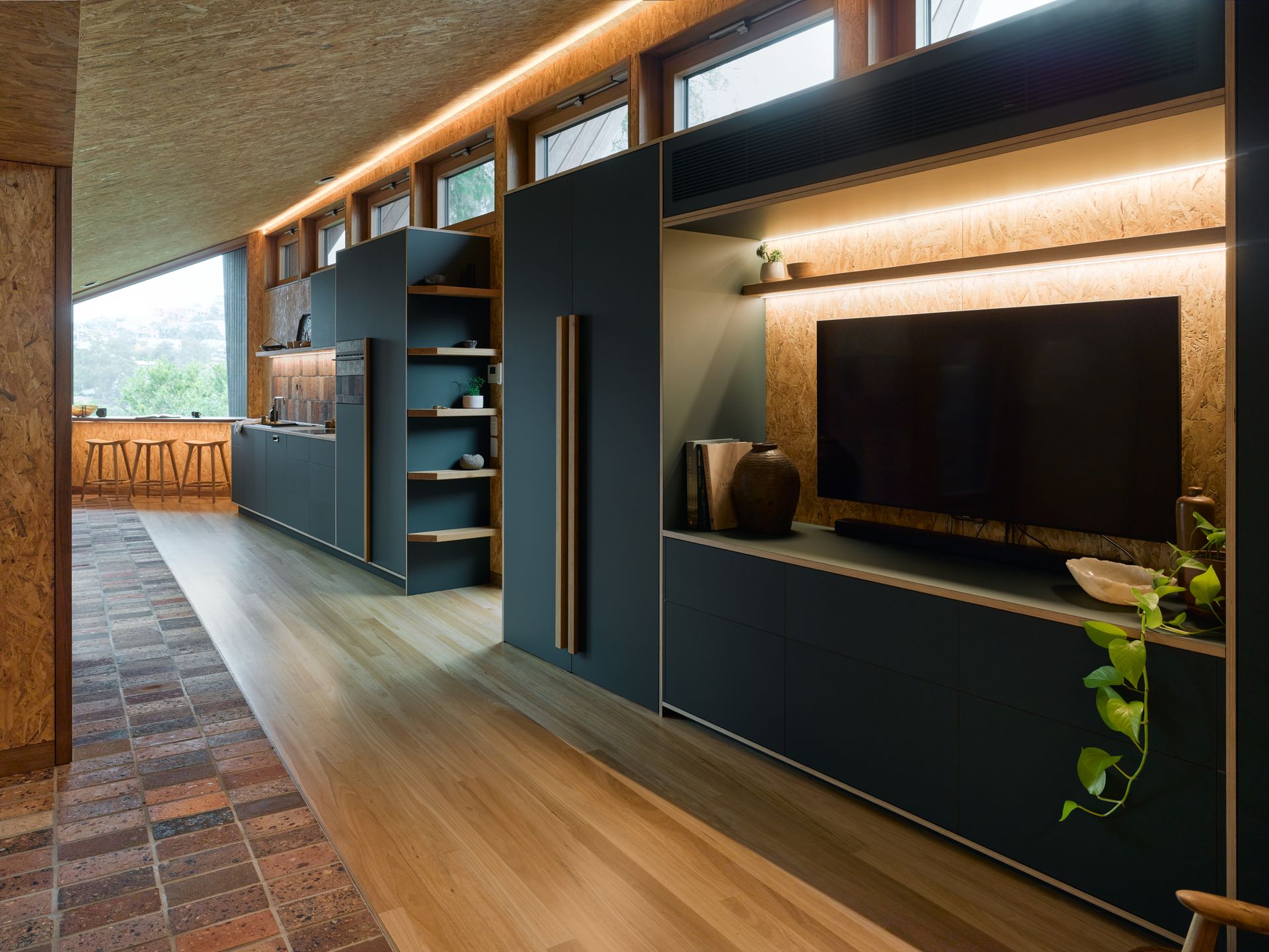 A modern living area with TV, dark blue cabinetry, cork walls and ceilings and wooden floors — Paiano Custom Kitchens In Corrimal, NSW
