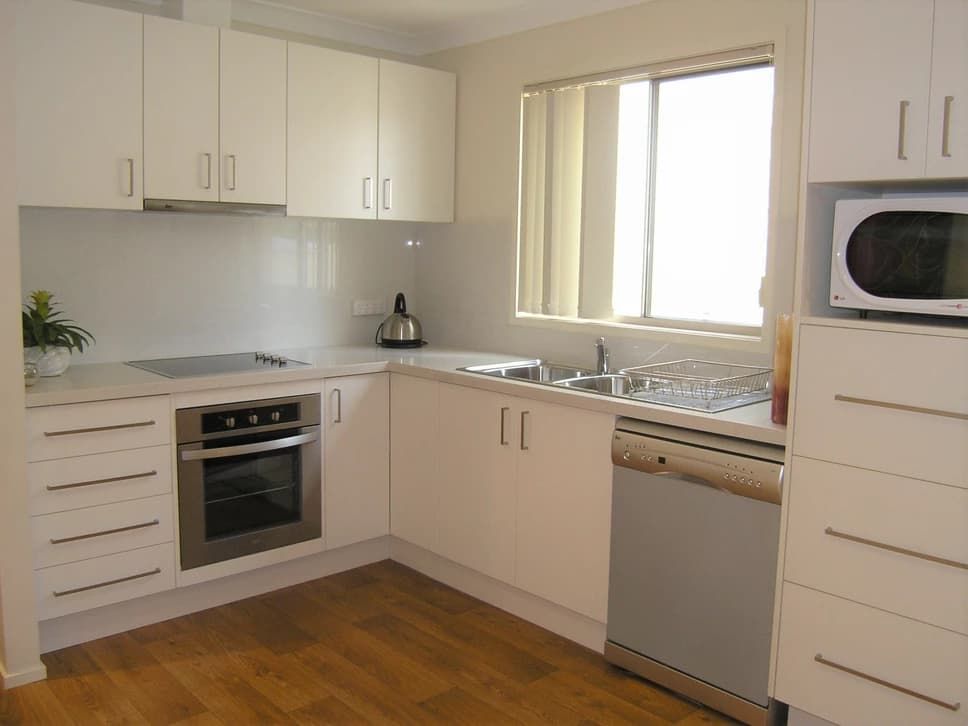 A Kitchen With White Cabinets and Stainless Steel Appliances — Paiano Custom Kitchens In Corrimal, NSW