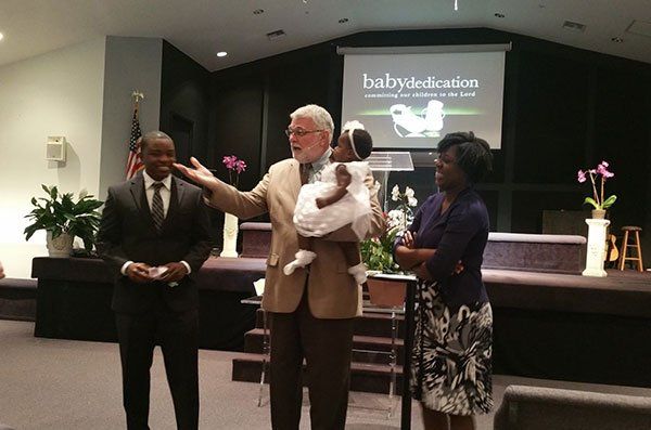 Pastor With The Baby — Naples, FL — Eagle's Nest Worship Center