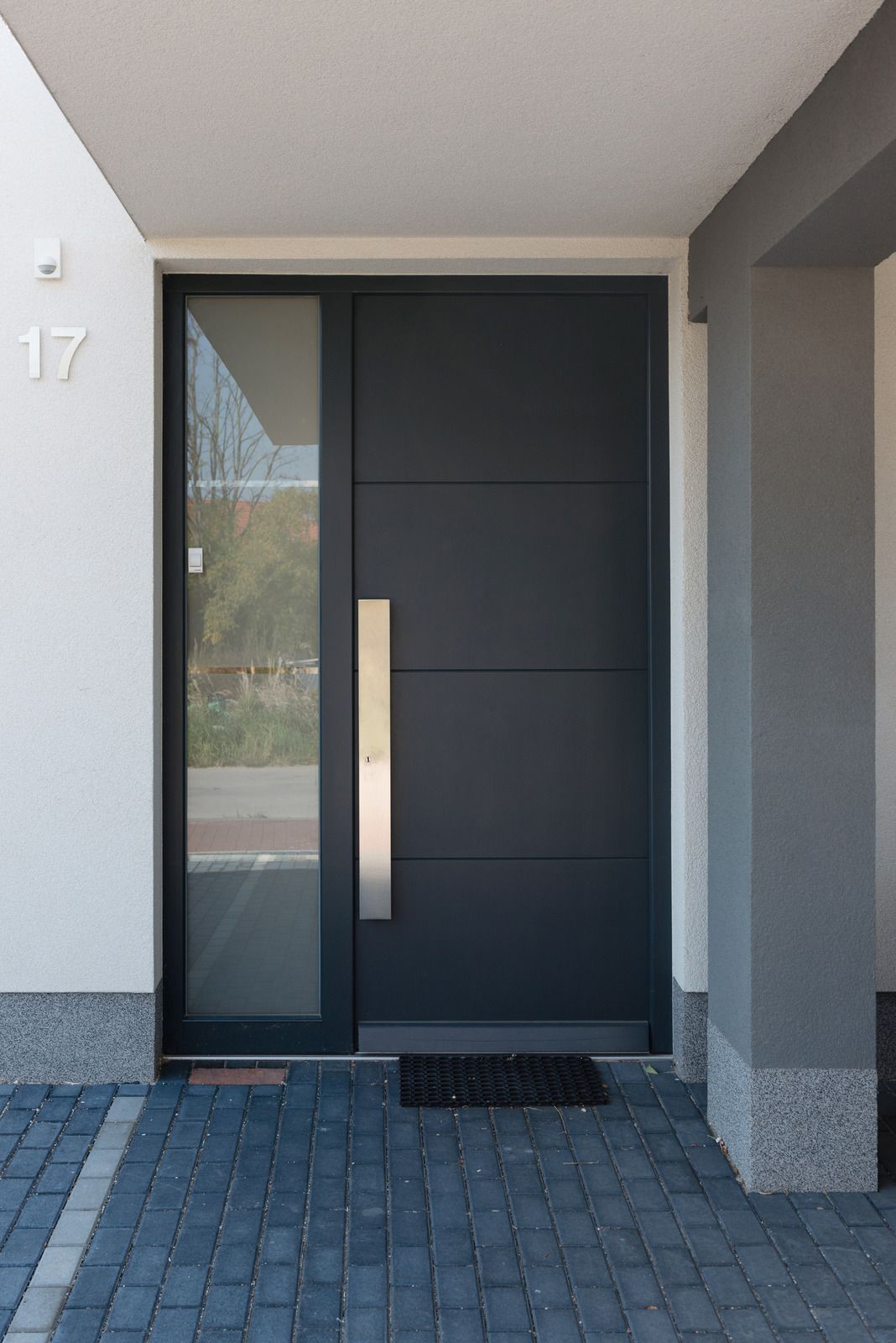 Modern front door with dark panels, vertical glass sidelight, and house number 17