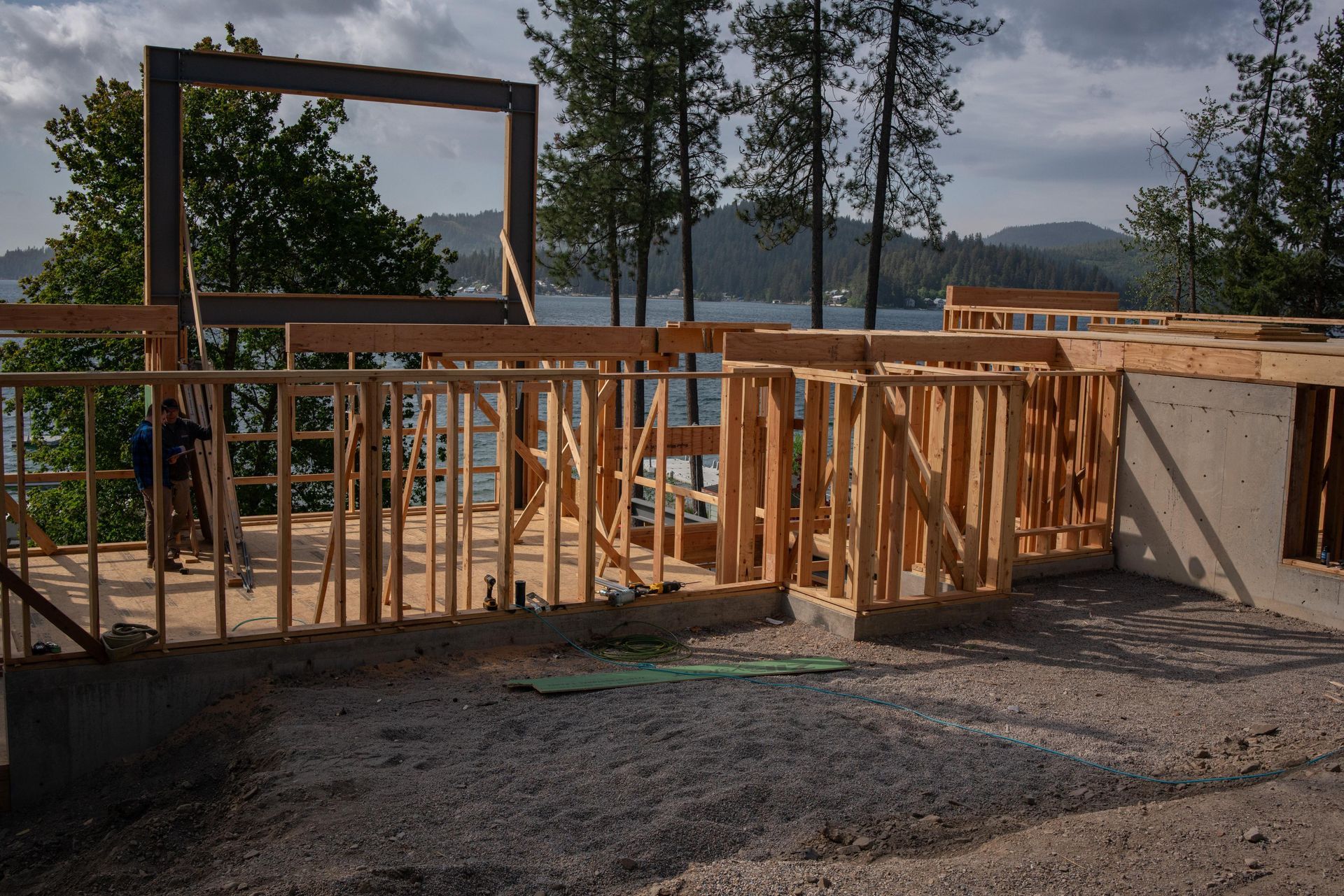 Wood-framed house under construction with a lakeside view in the background