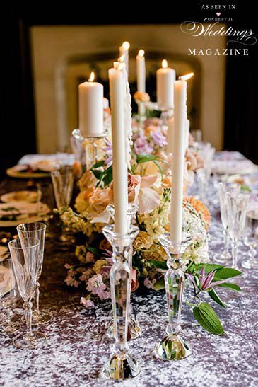 A long table with candles and flowers on it.