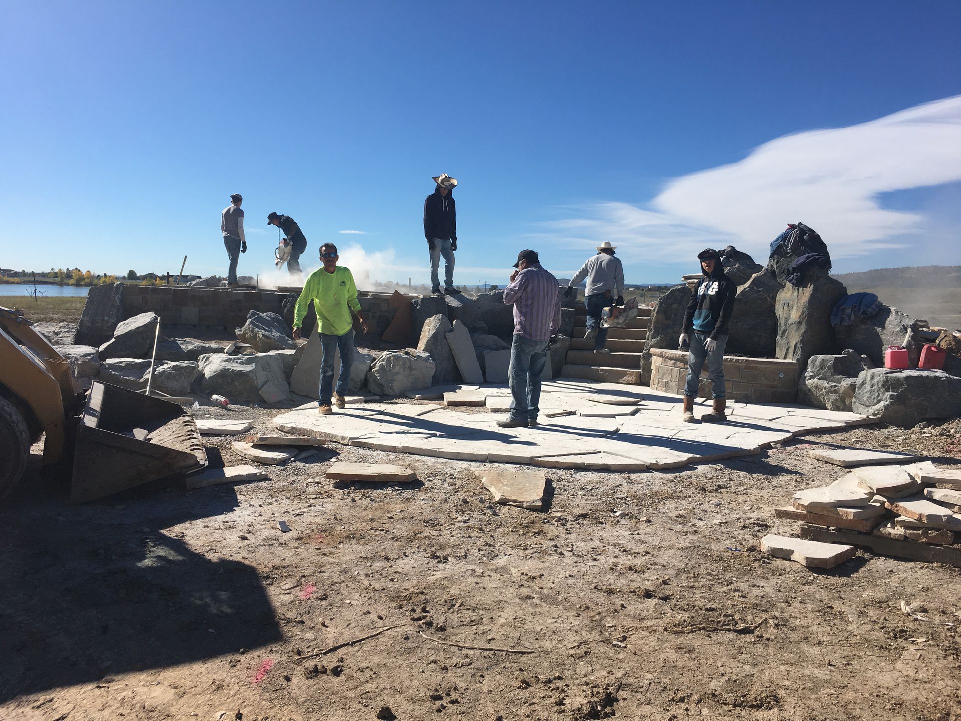 A group of people standing on top of a pile of rocks.