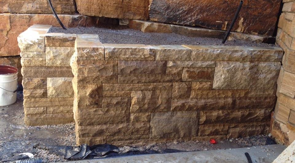 A brick wall with a bucket of paint in the background.