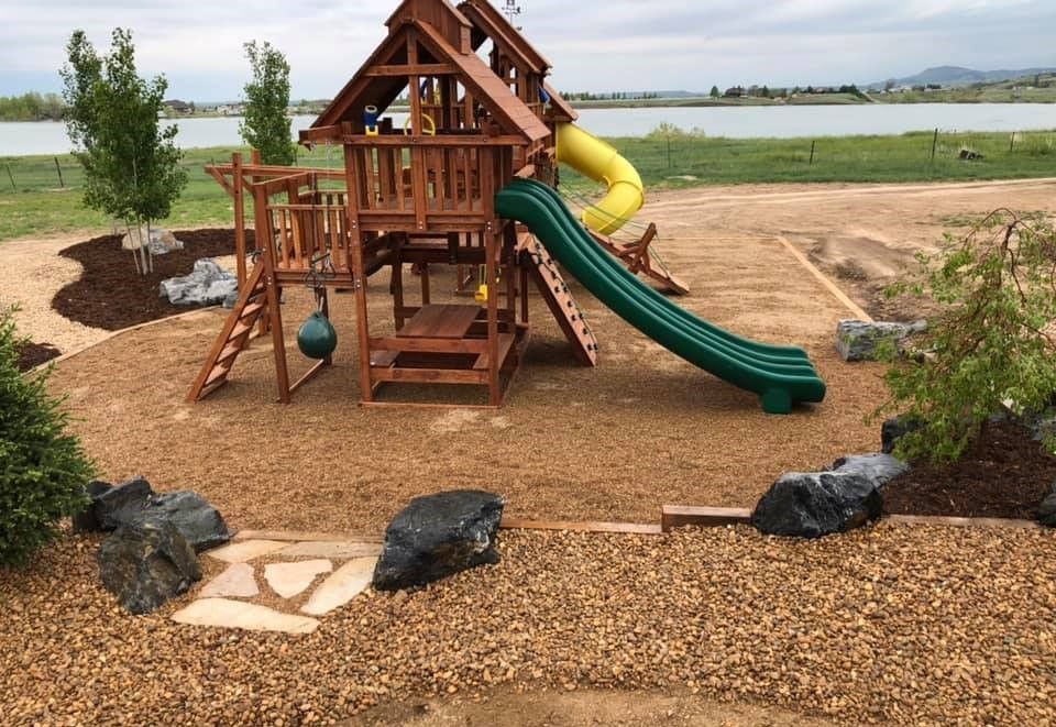 A wooden playground with a green slide and a yellow slide