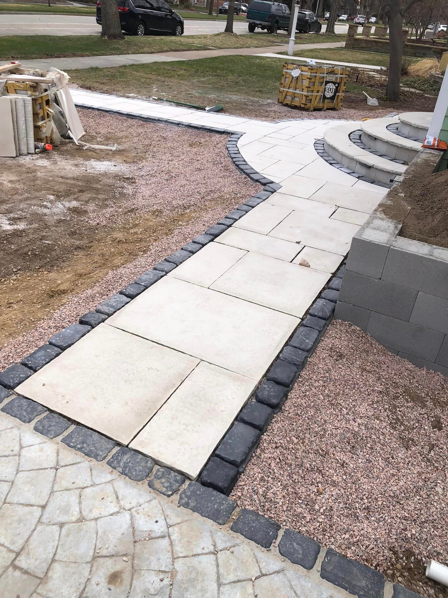 A concrete walkway is being built in a yard.