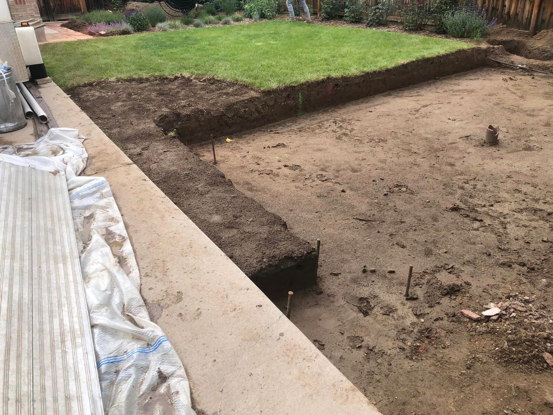 A large pile of dirt is sitting next to a lush green lawn.