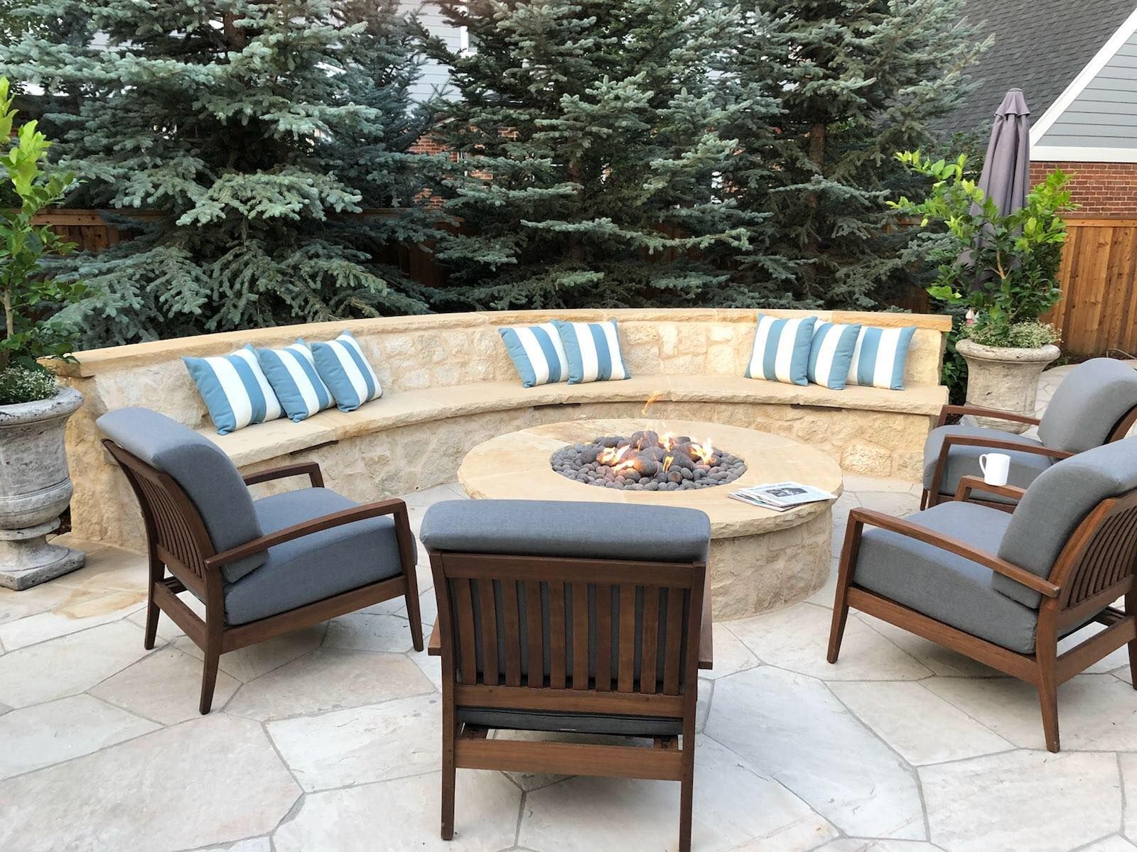 There is a fire pit in the middle of the patio surrounded by chairs.