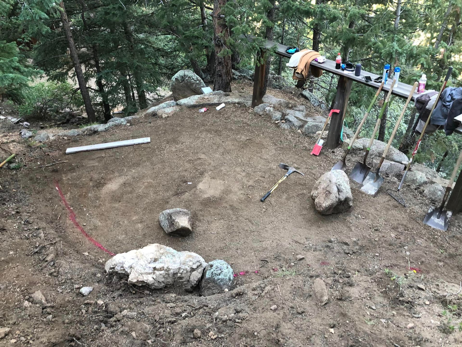A pile of dirt and rocks in the middle of a forest.