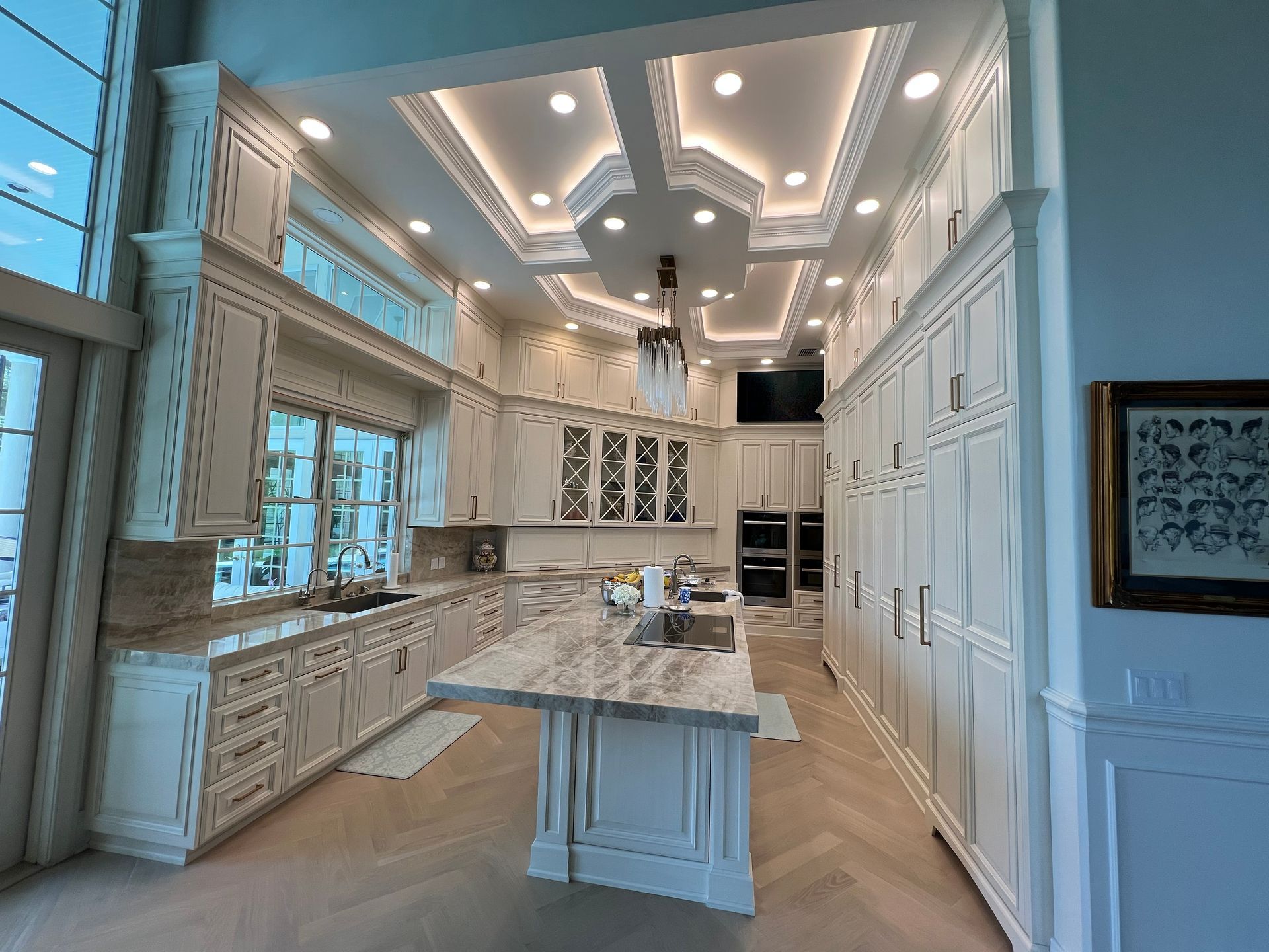 A large kitchen with white cabinets and a large island in the middle.