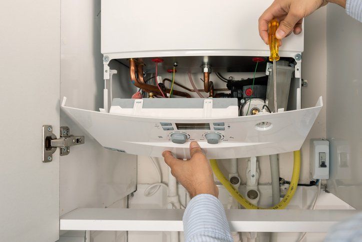 Technician Repairing Water Heater — Rockford, IL — ProTech Plumbing Heating & Cooling