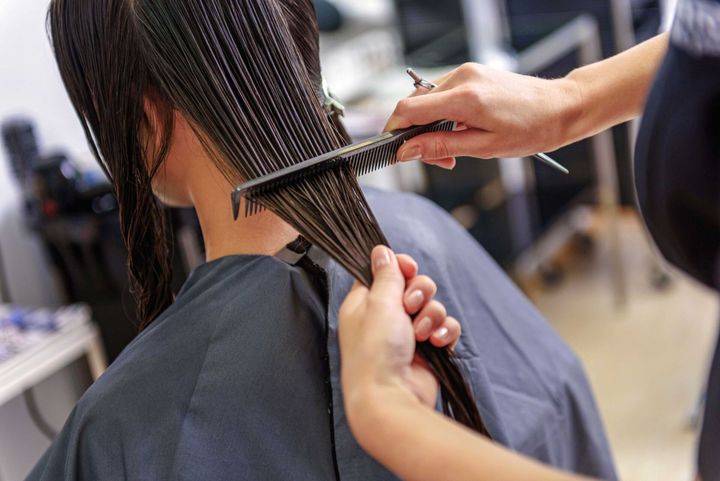 Parrucchiere che taglia i capelli a una cliente