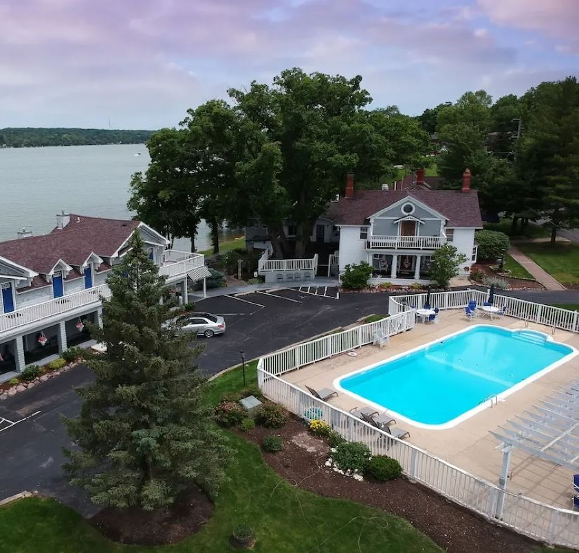 An aerial view of a house with a large swimming pool in front of it