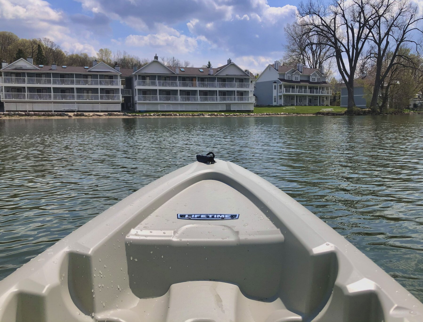 A kayak is floating on a lake with buildings in the background