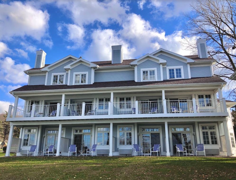 A large house with a lot of windows and chairs in front of it.