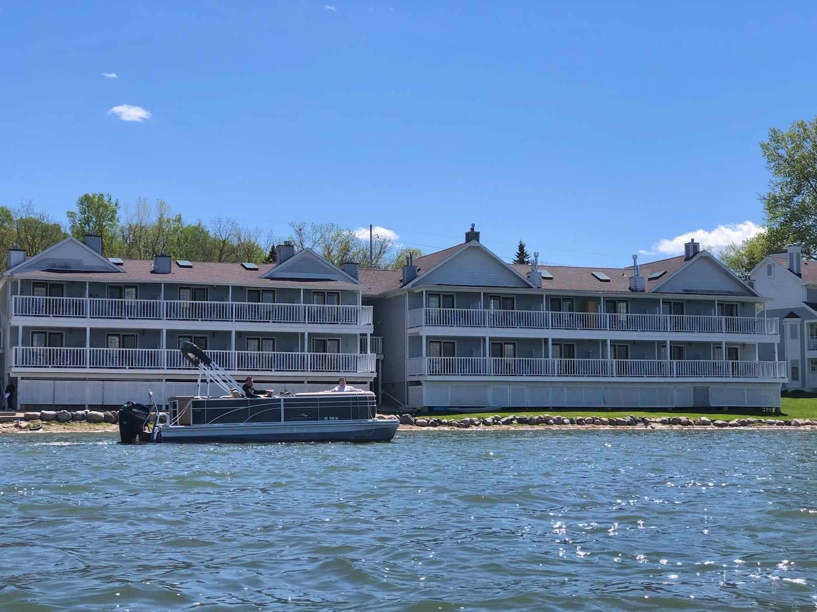 A boat is docked in front of a building on a lake