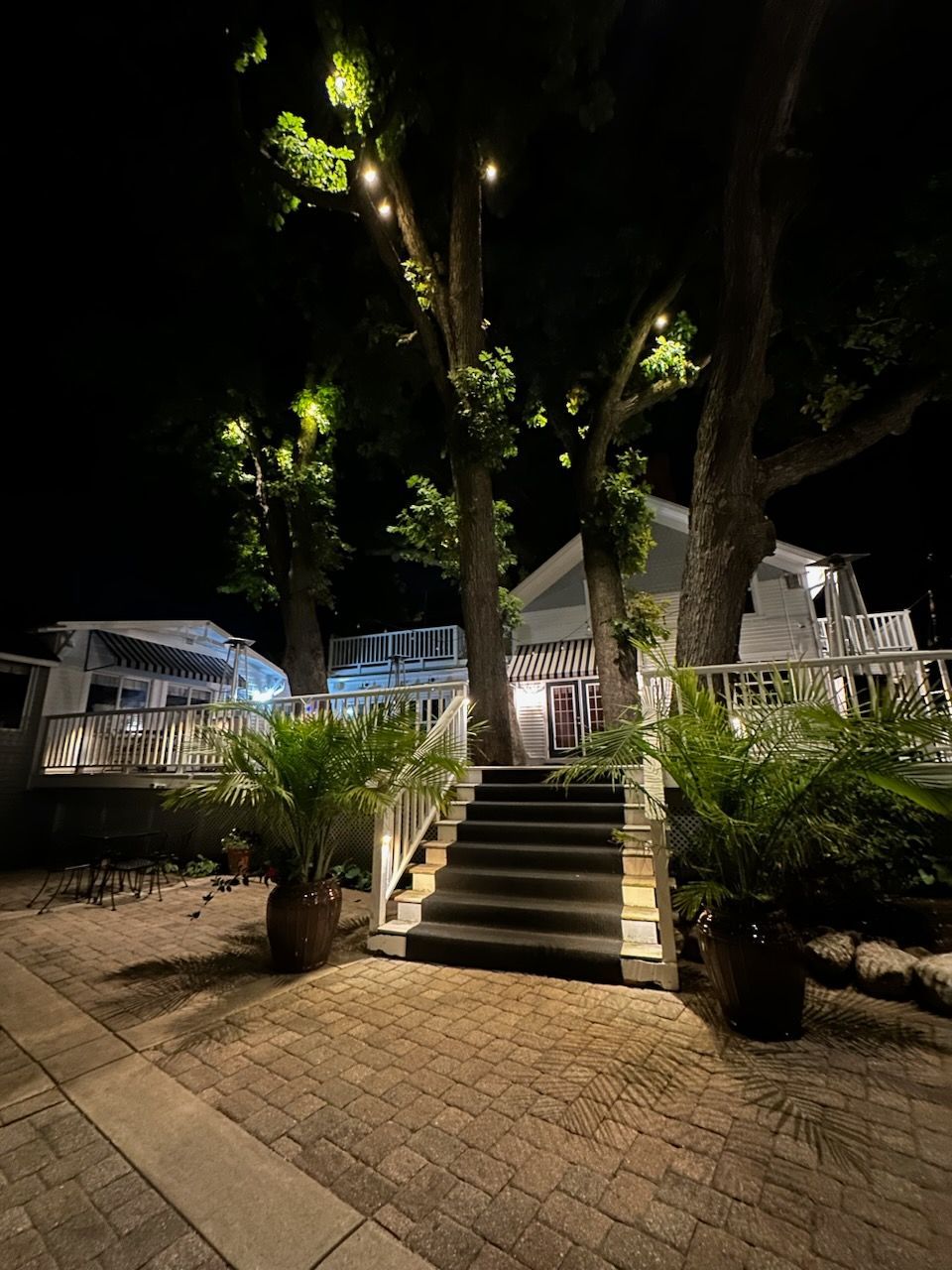 A house with stairs leading up to it is lit up at night.