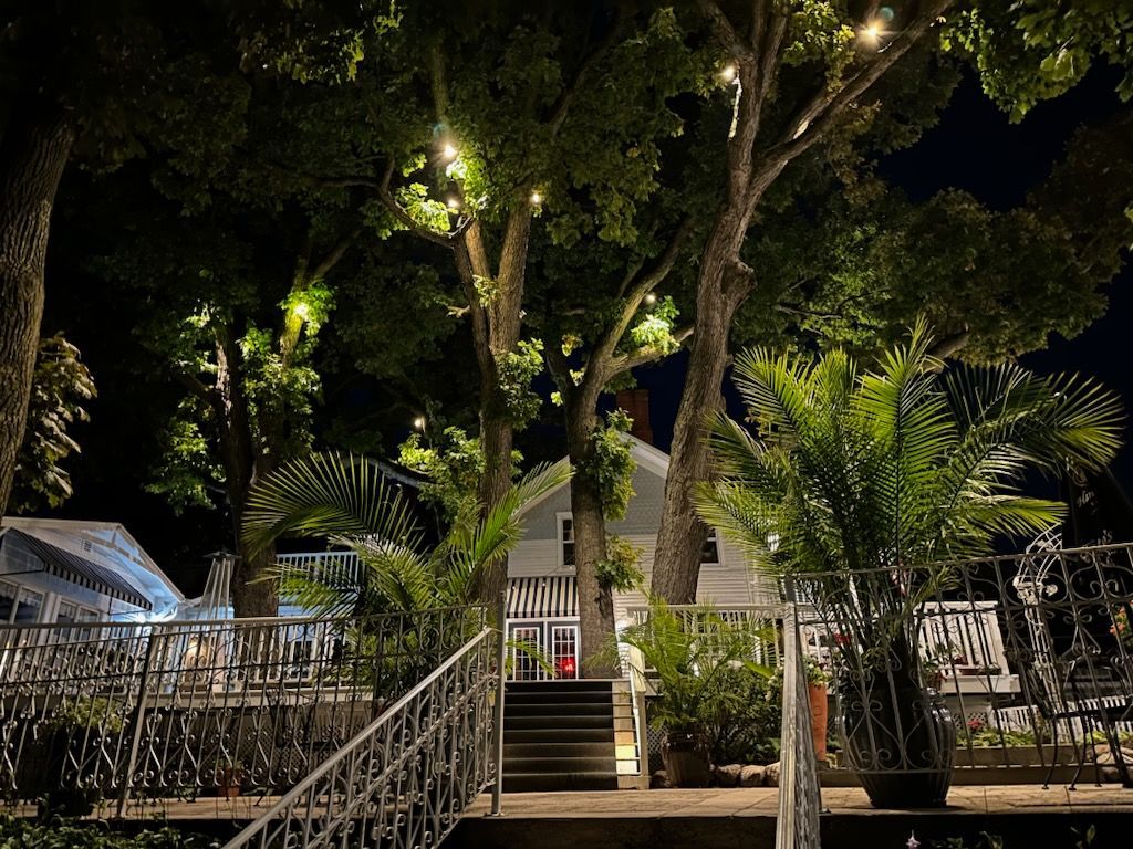 A house with stairs leading up to it is lit up at night.