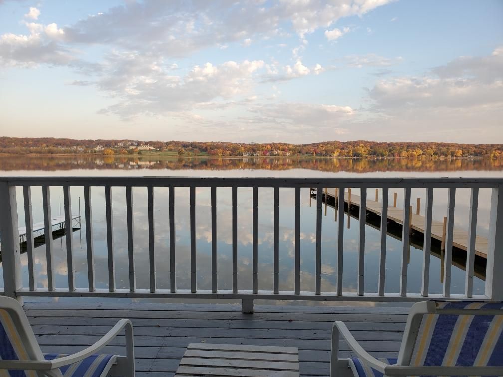 Two chairs on a deck overlooking a body of water