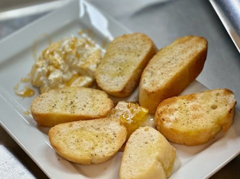A white plate topped with slices of garlic bread and a sauce.