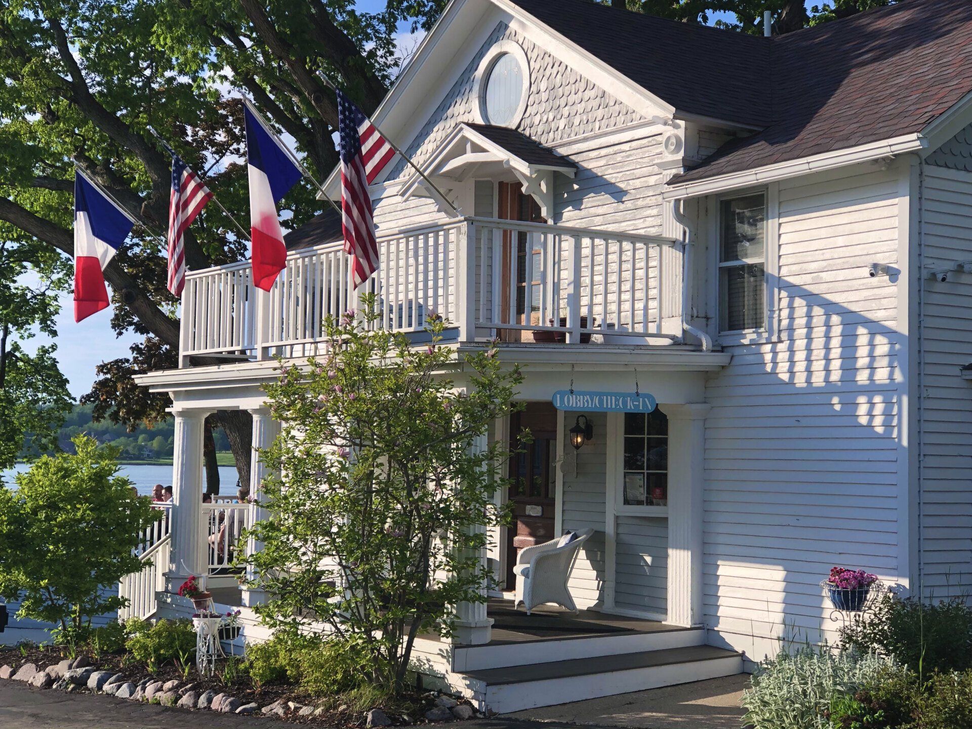A white house with french and american flags on the porch