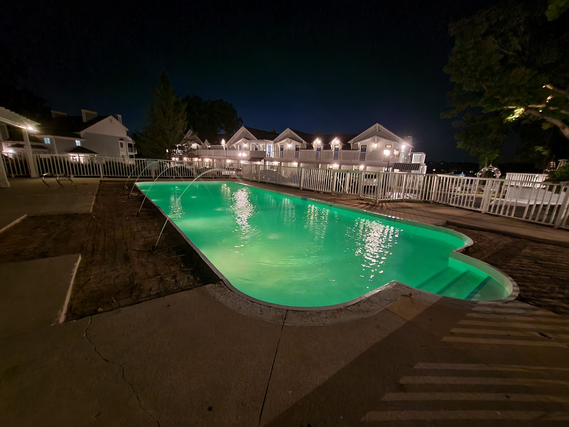 A large swimming pool is lit up at night.