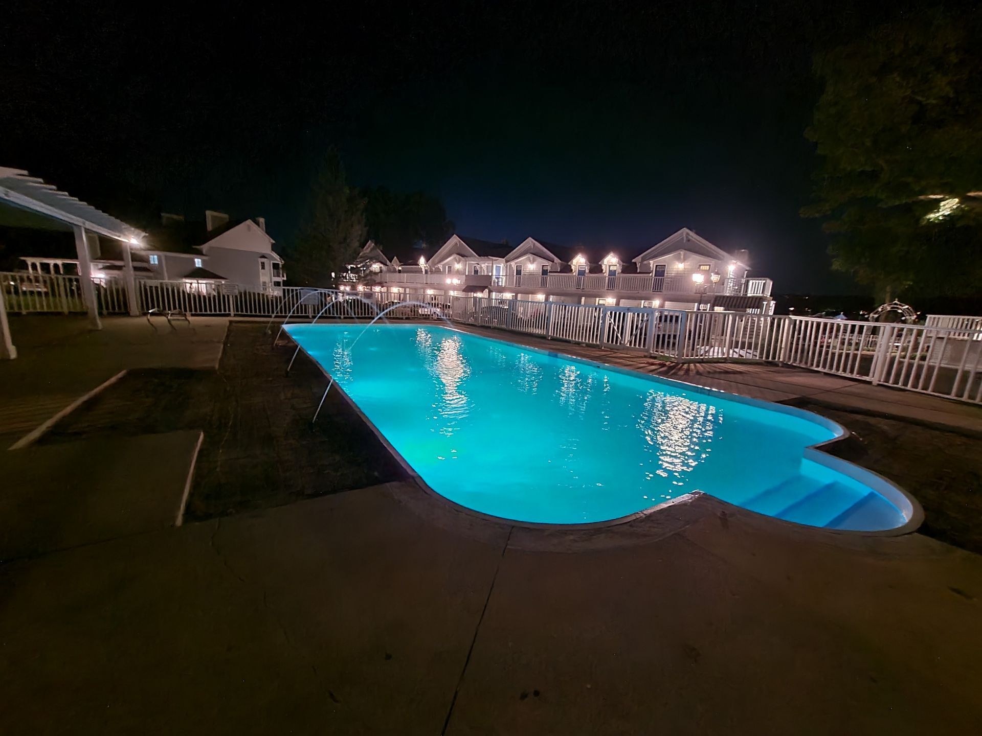 A large swimming pool is lit up at night.
