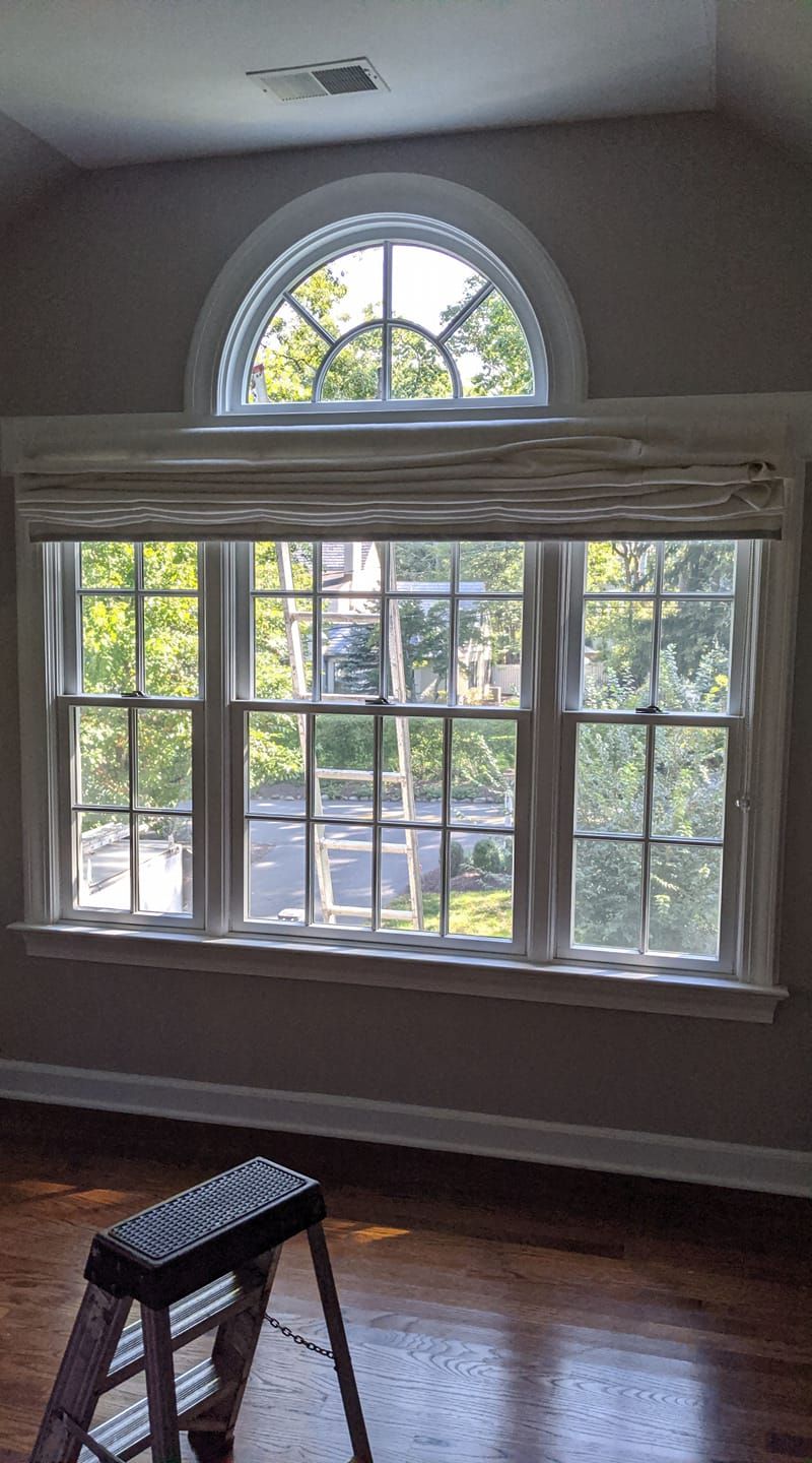 A room with a large window and a ladder in front of it.