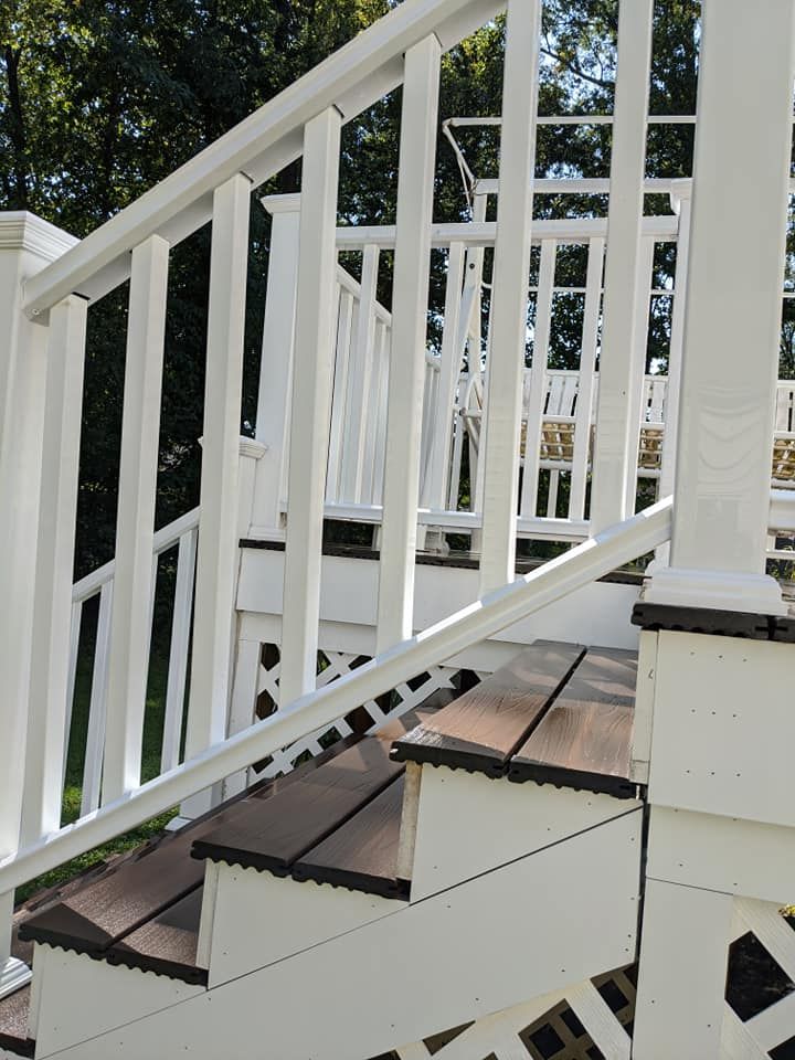 A white railing on a set of wooden stairs