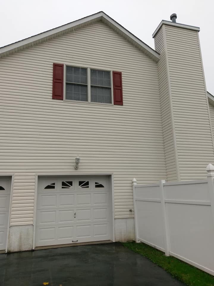 A white house with red shutters and a white fence
