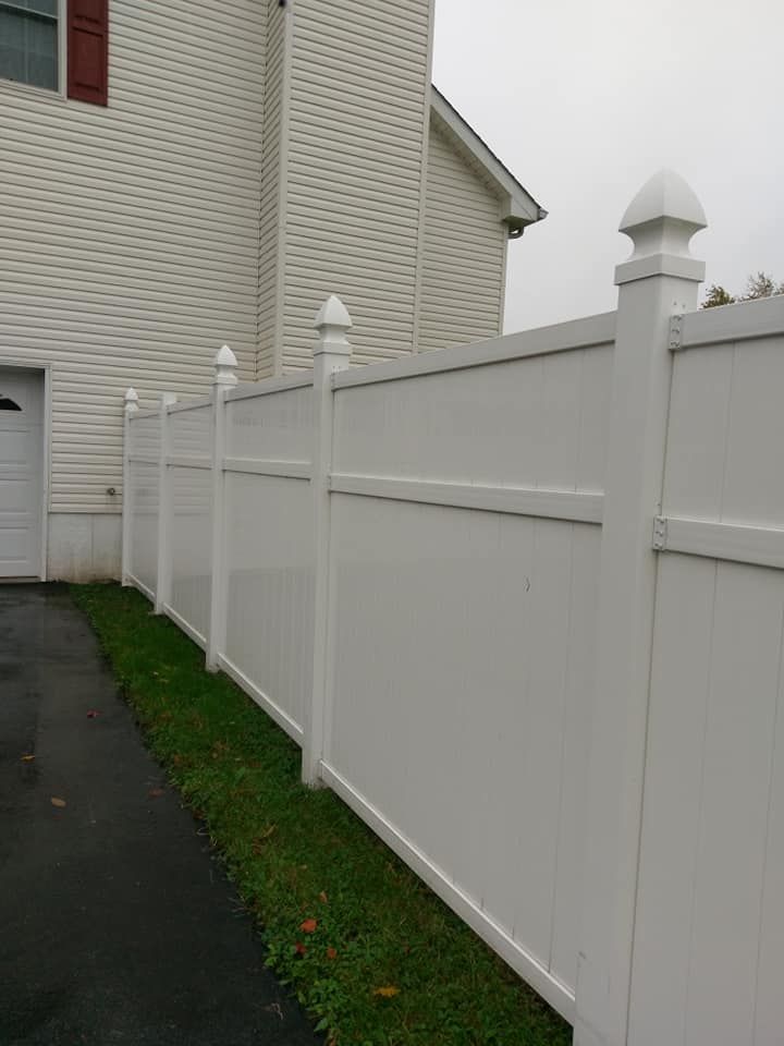 A white fence with a house in the background