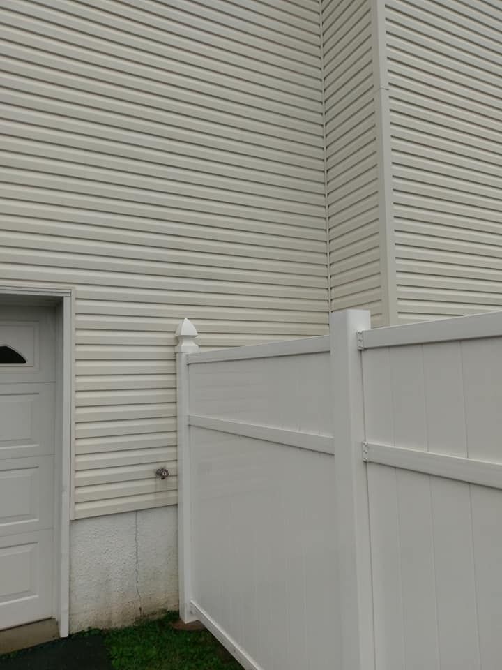 A person is using a high pressure washer to clean a brick walkway.