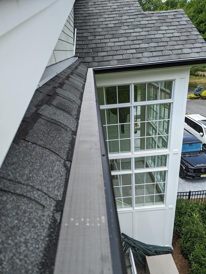 A white house with a gutter on the side of it.