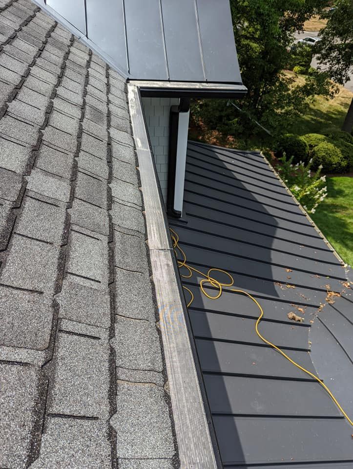 A close up of a roof with shingles and a gutter.