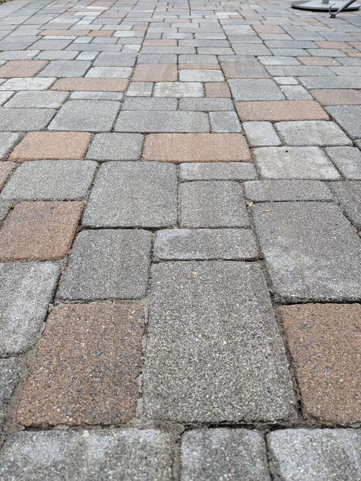 A close up of a brick walkway with a bicycle in the background.