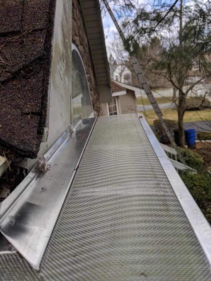 A close up of a gutter on the side of a house.