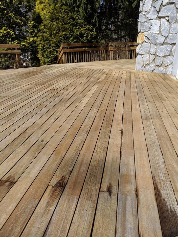 A wooden deck with a stone wall in the background.