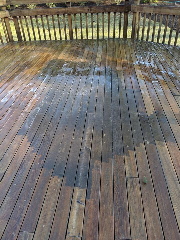 A wooden deck is being cleaned with a pressure washer.