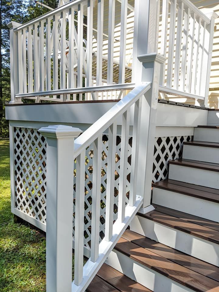 A deck with stairs leading up to it and a white railing