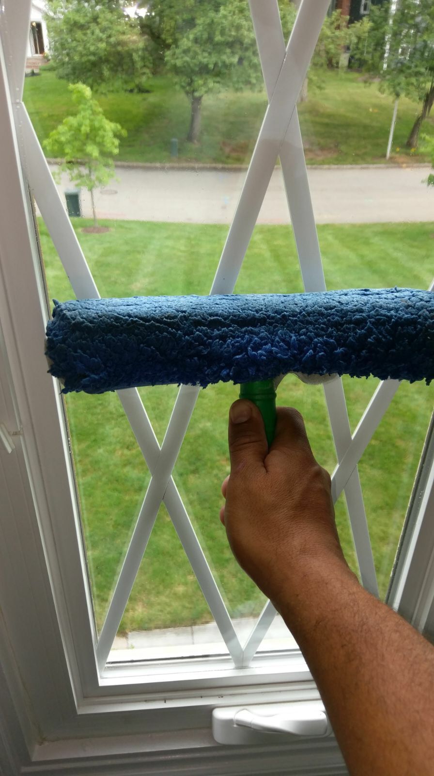 A person is cleaning a window with a squeegee.