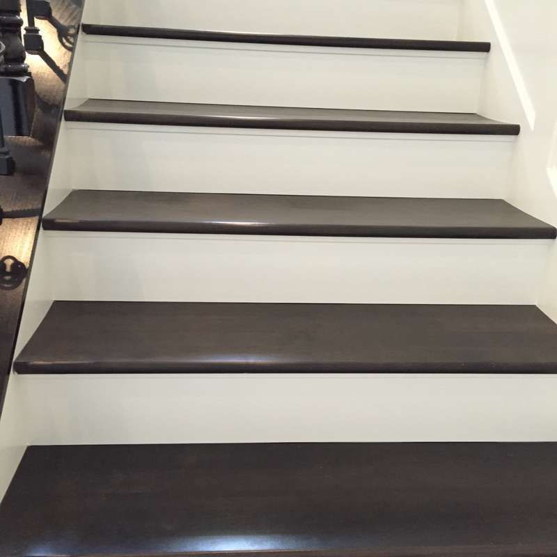 Carpeted staircase with dark brown treads and white risers, viewed from below