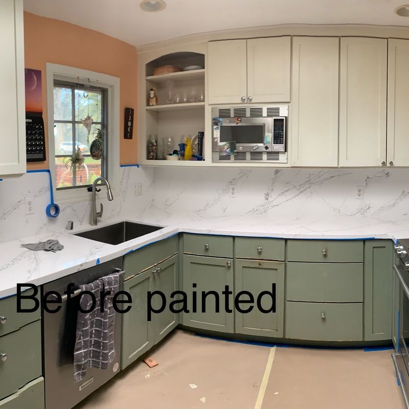 L-shaped kitchen with cream cabinets, marble-look backsplash, black sink, and green lower cabinets labeled “Before painted”