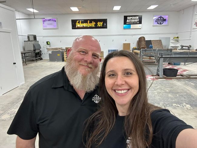 A man and a woman are posing for a selfie in a room.