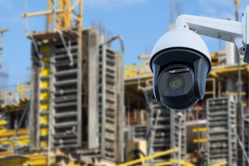 Security camera mounted at a construction site, capturing activity near scaffolding.