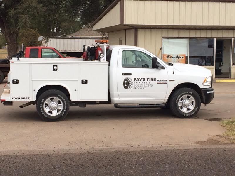 White service truck with toolboxes parked in front of a building; 
