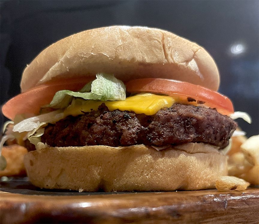 A hamburger and french fries with a side of baked beans at Smokehouse BBQ
