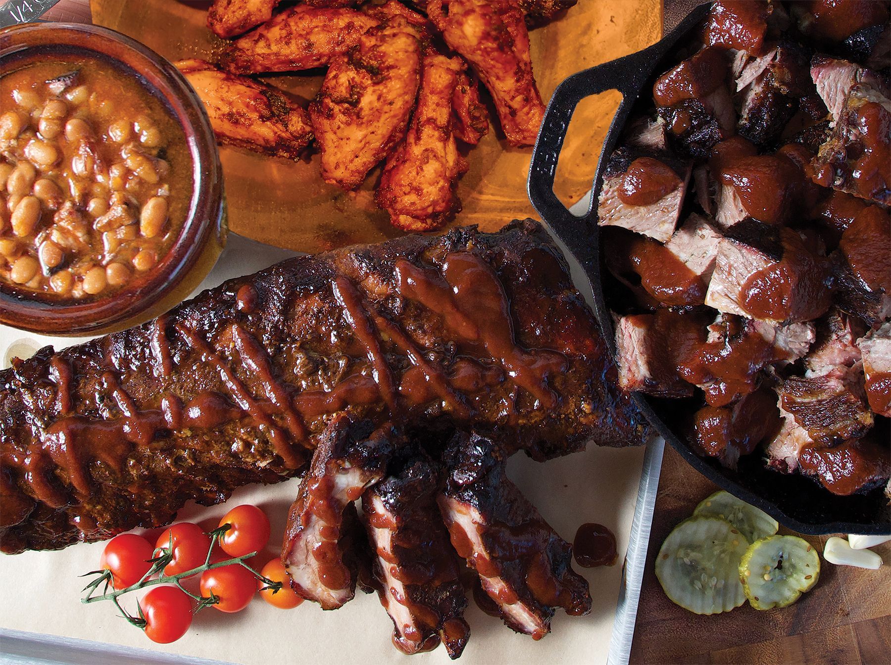 Delicious barbecue platter with ribs bisket, baked beans, and chicken wings at smokehouse bbq restaurant