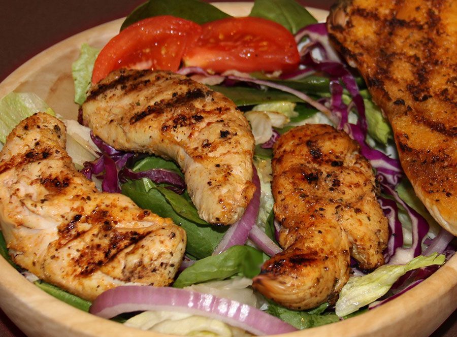 white bowl filled with grilled chicken , lettuce , tomatoes and garlic bread near me